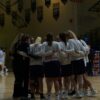 basketball team in middle of basketball court