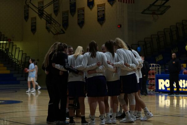 basketball team in middle of basketball court